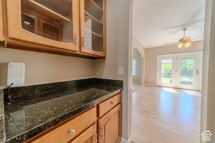 Built-in cabinetry with glass-front upper cabinets and a dark granite-finish countertop