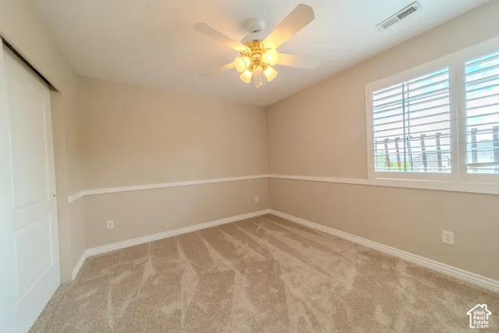 Carpeted interior space featuring neutral wall tones with decorative chair rail molding