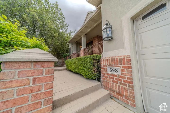 Brick and stucco exterior featuring a built-in outdoor lantern and a garage with a panel door