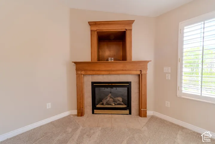 Corner fireplace featuring a wood mantelpiece, tile surround, and a built-in media niche