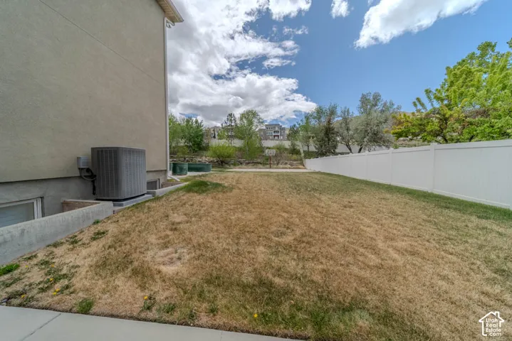 Expansive lawn area with a white privacy fence