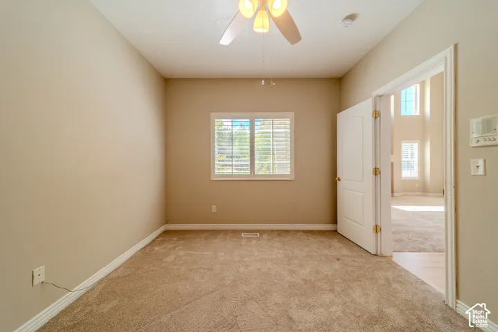 Carpeted room with neutral tone walls and white baseboards