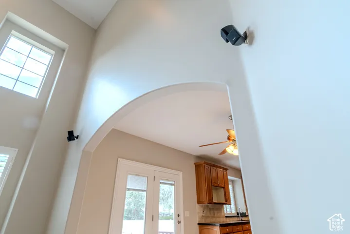 Soaring ceiling with a large transom window and arched entryway