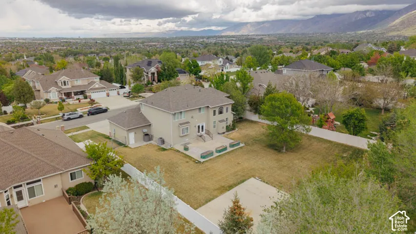Expansive property featuring a multi-level home with a neutral stucco exterior, a large rear patio, and a spacious lawn area