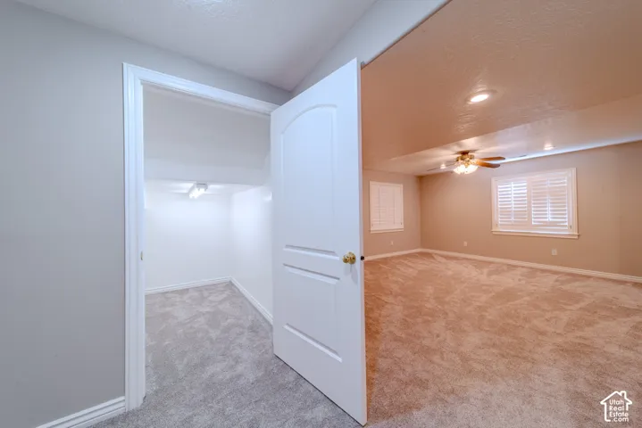 Spacious room featuring neutral carpeting, recessed lighting, and a ceiling fan