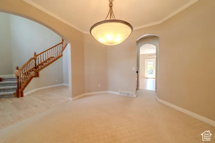 Recessed dining space featuring crown molding and a semi-flush mount chandelier