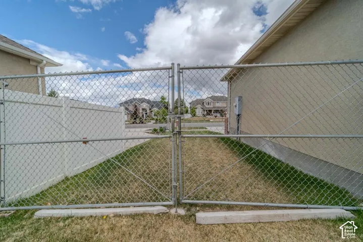 Chain link fence enclosing a grassy area, featuring a white vinyl privacy fence