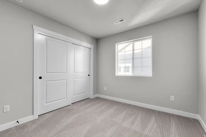 Room featuring neutral gray walls and light gray patterned carpet