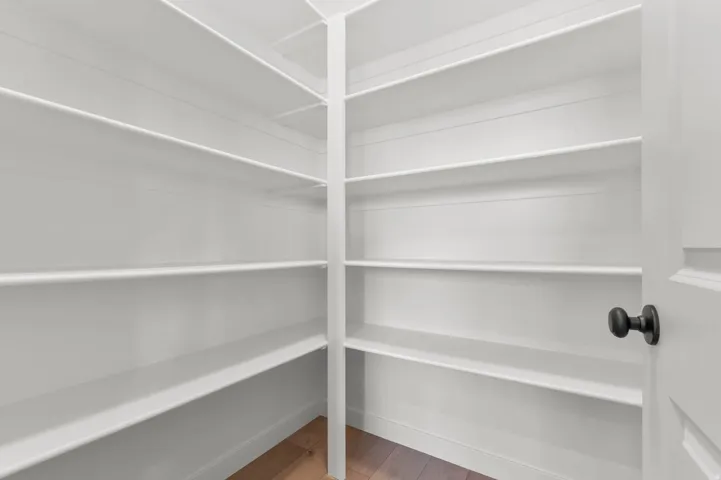 Walk-in pantry featuring extensive white shelving