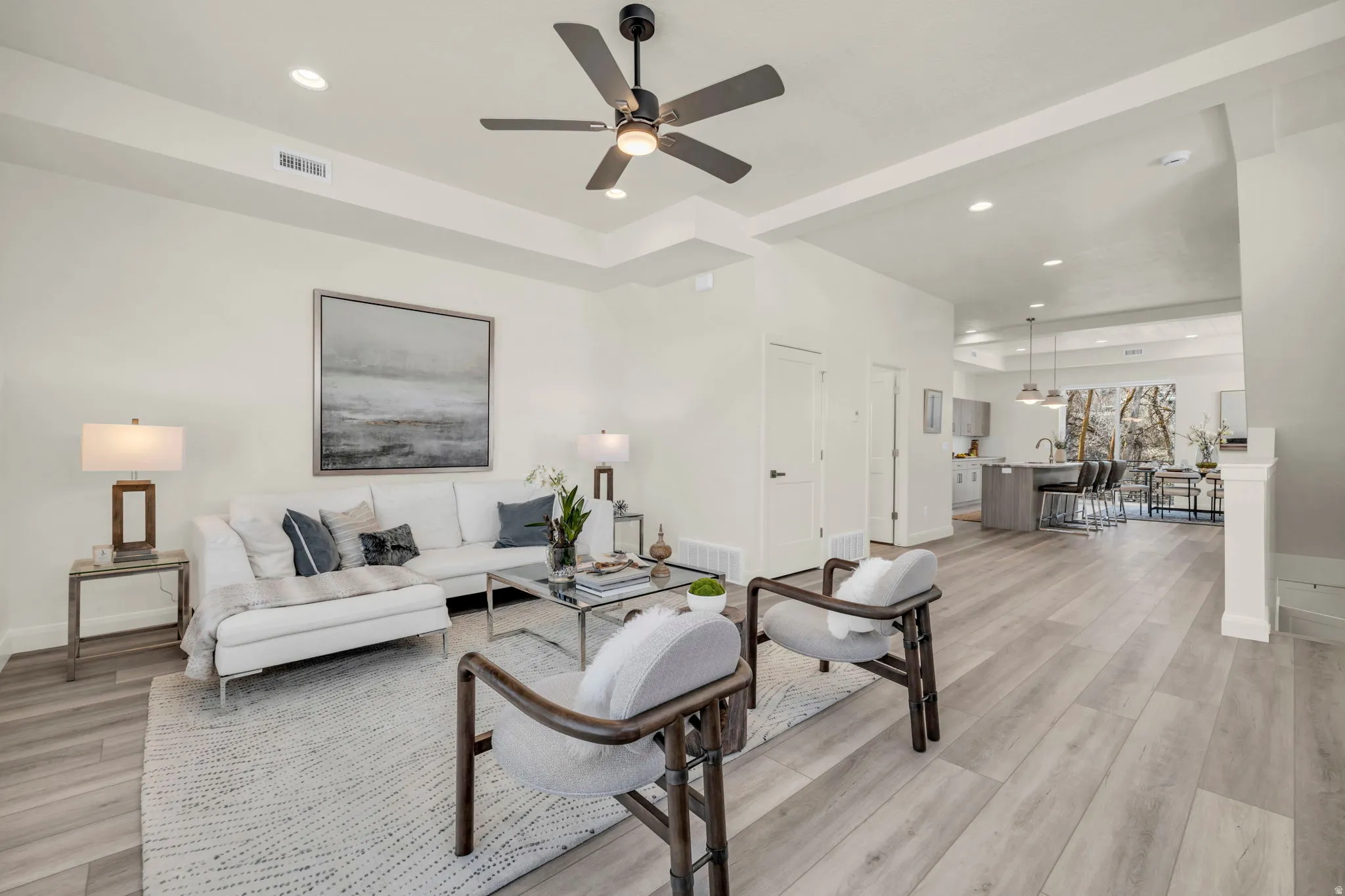 Open-concept living space featuring wood-finish flooring, recessed lighting, and a contemporary ceiling fan