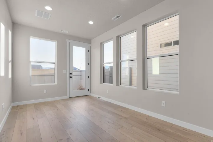 Bright interior space featuring light wood-finish flooring and multiple windows