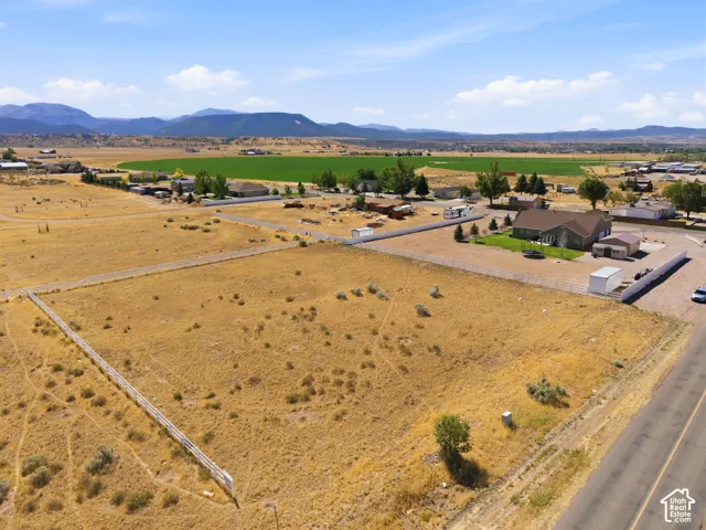 Expansive undeveloped lot featuring a white fence, mature sagebrush, and a single tree