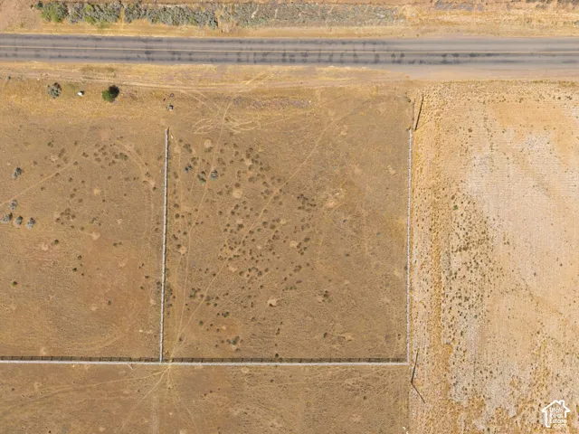 Expansive undeveloped land parcel with a visible paved road frontage