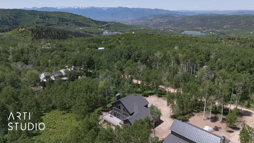 Contemporary mountain home featuring a dark-toned exterior, multiple gables, and a prominent chimney