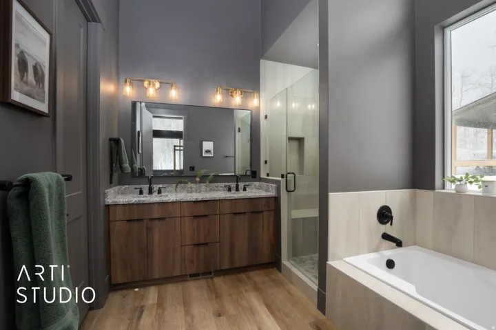 Bathroom featuring a dual-sink vanity with a granite countertop, wood-finish cabinetry, and matte black fixtures