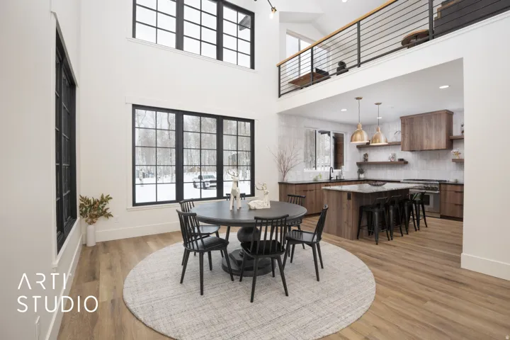 Soaring ceilings and large black-framed windows illuminate this open-concept space