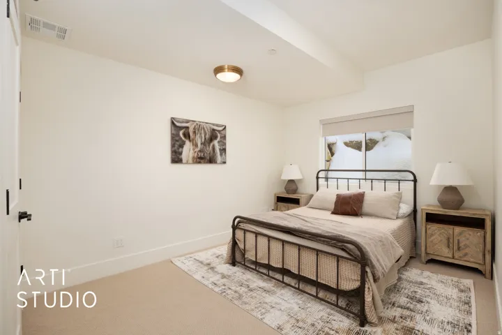 Carpeted bedroom featuring a metal bed frame, recessed lighting, and a large window