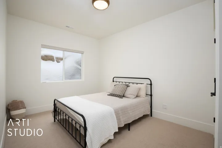 Interior room with light-colored carpeting, a window with a roller shade, and a flush-mount ceiling light fixture