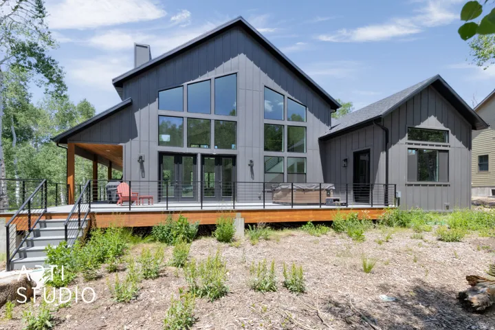 Contemporary exterior with dark vertical siding and a multi-level deck
