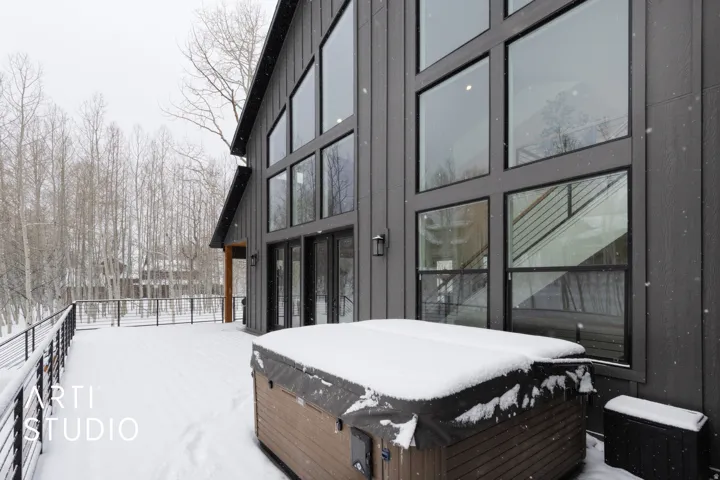 Modern exterior featuring dark vertical siding and a multi-level window arrangement