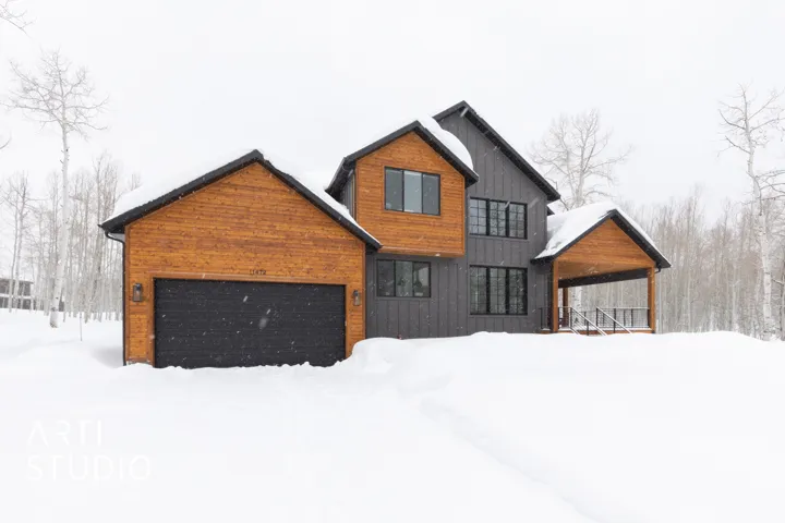 Contemporary exterior featuring dark vertical siding and warm wood accents