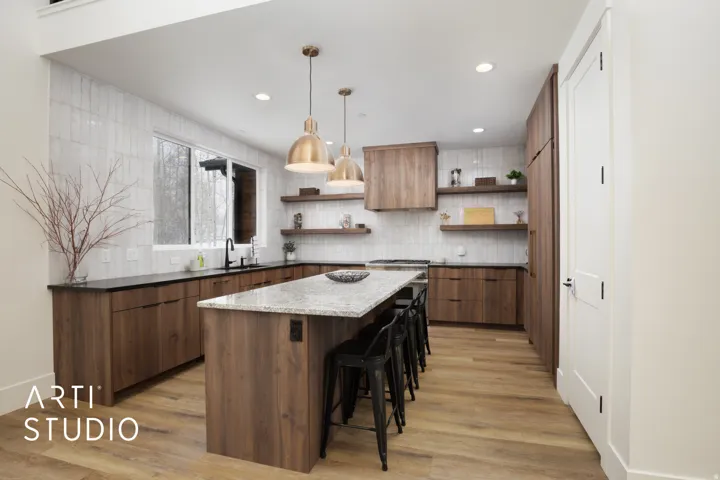 Contemporary kitchen featuring wood-finish cabinetry, a large center island with a light-toned countertop, and light wood-finish flooring