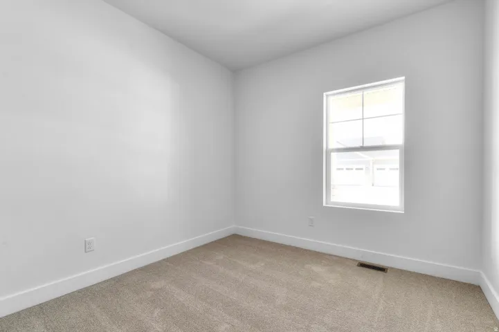 Neutral tone carpeting and white baseboards