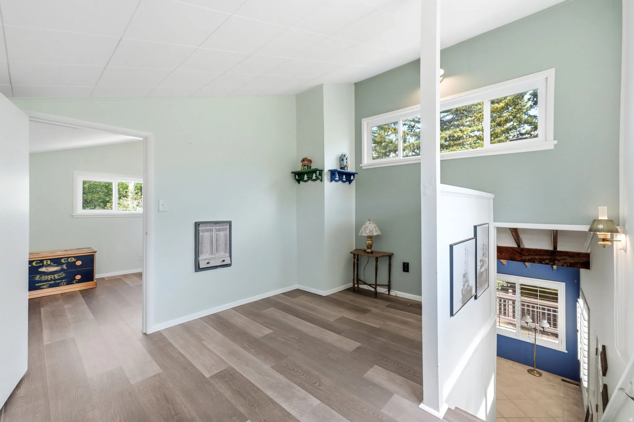 Interior space featuring wood-finish flooring, light green wall paint, and multiple windows