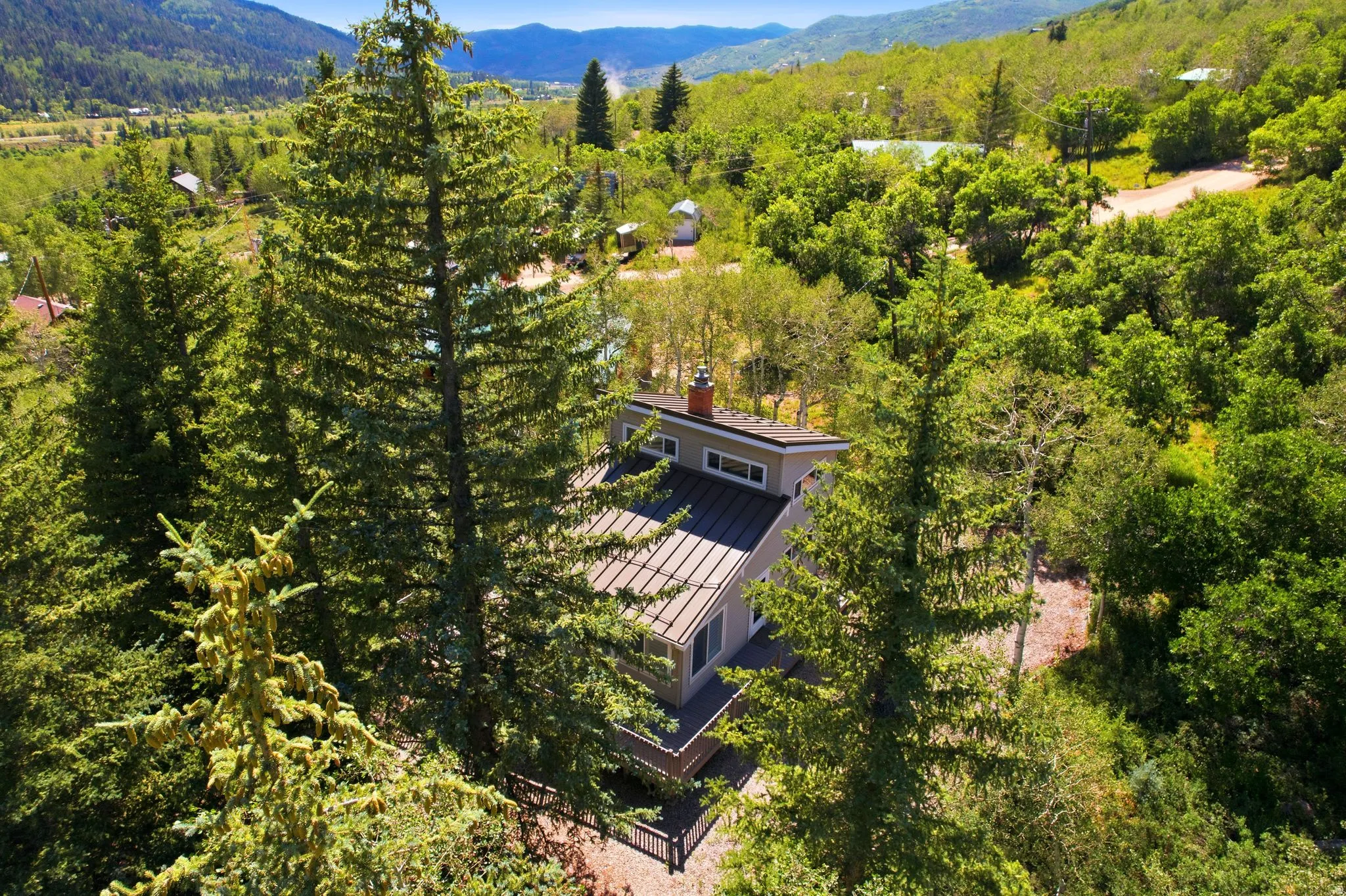Modern mountain-style residence featuring a dark metal roof and light-toned siding
