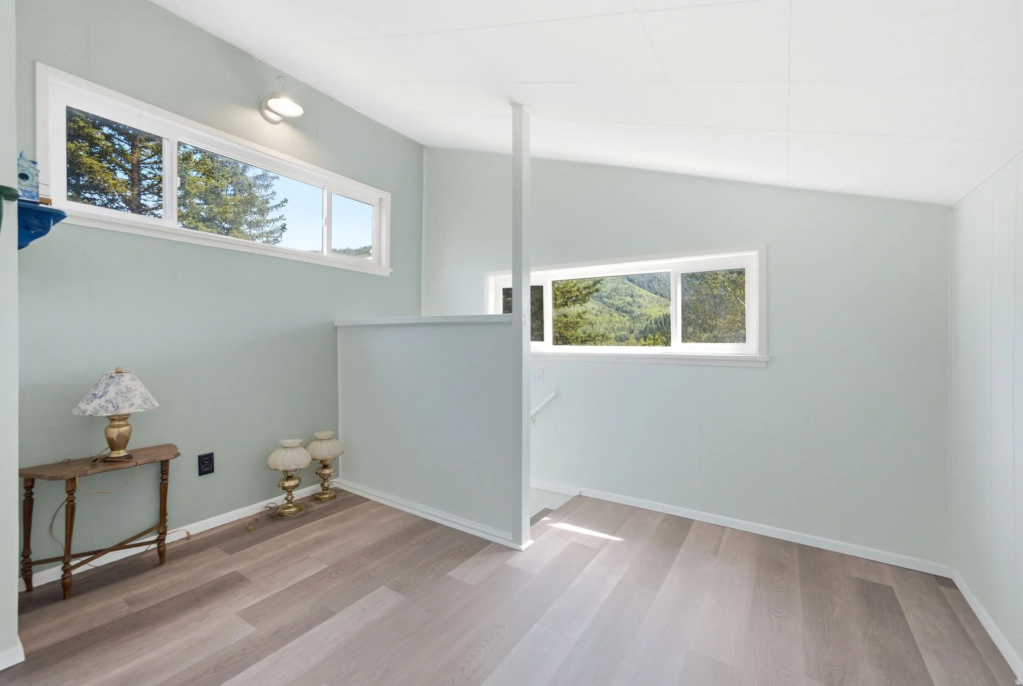 Interior space featuring wood-finish flooring, light-toned walls, and multiple windows