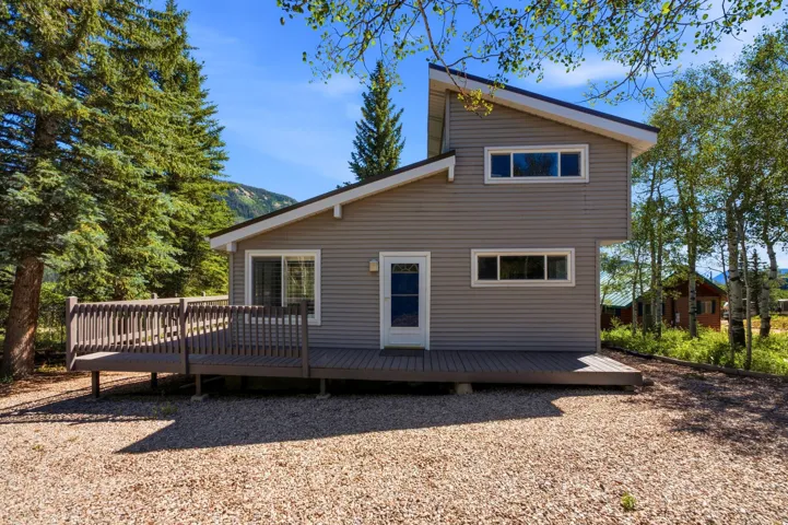 Contemporary-style home featuring horizontal siding, a sloped roofline, and a multi-level deck