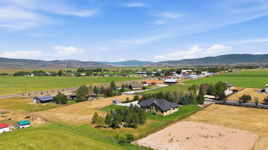 Expansive rural landscape with a single-family residence featuring a dark-toned roof