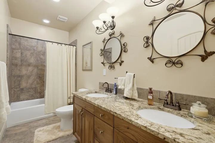 Double vanity featuring granite countertops and undermount sinks