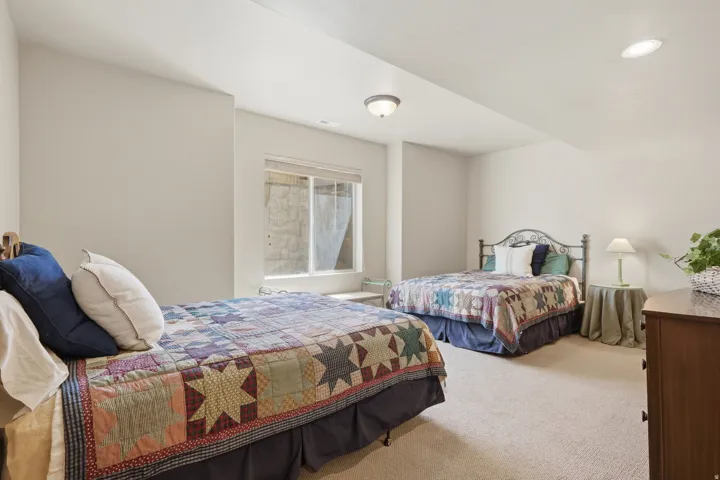 Carpeted room featuring a wide window, two ceiling-mounted light fixtures, and neutral wall tones