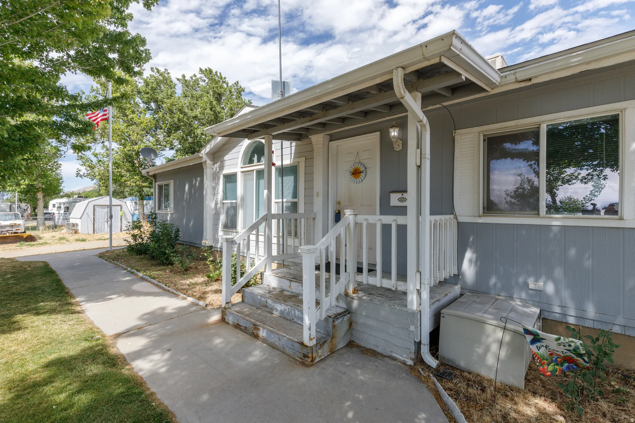 Covered front porch with white railings and steps
