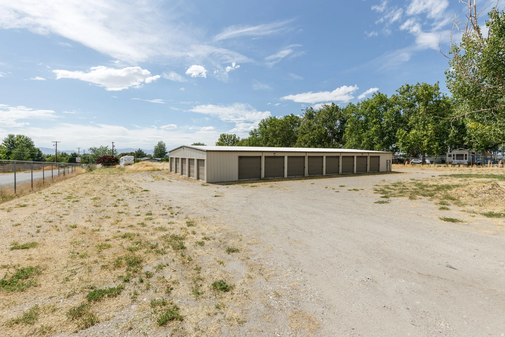 Multi-unit storage building featuring numerous roll-up garage doors and a metal exterior