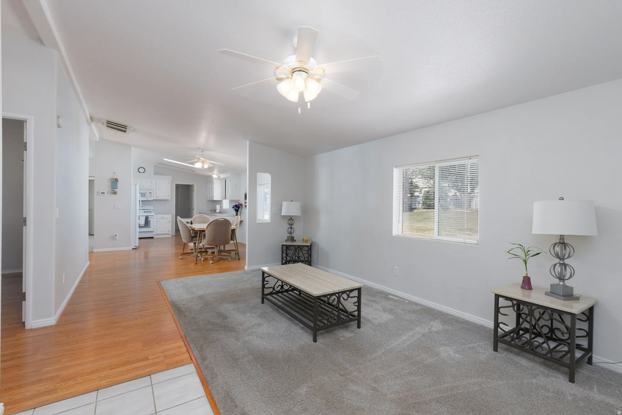 Spacious interior featuring a vaulted ceiling and a ceiling fan with integrated lighting