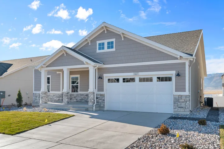 Craftsman-style exterior featuring a covered front porch with stone accents