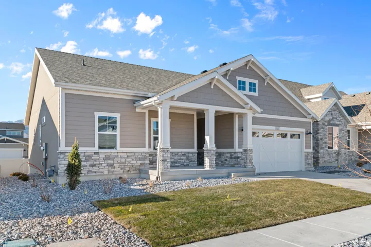 Contemporary ranch-style residence featuring a prominent front porch with white columns and stone accents
