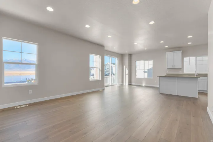 Open-concept living space featuring wood-finish flooring, recessed lighting, and ample natural light from multiple windows