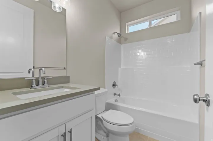 Bathroom featuring a white vanity with a light-toned countertop, a rectangular undermount sink, and a chrome faucet