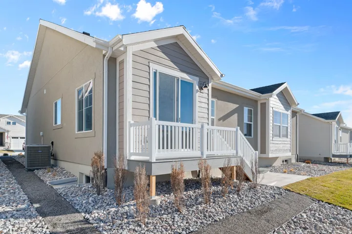 Exterior featuring a light stucco finish with light gray siding accents and white trim