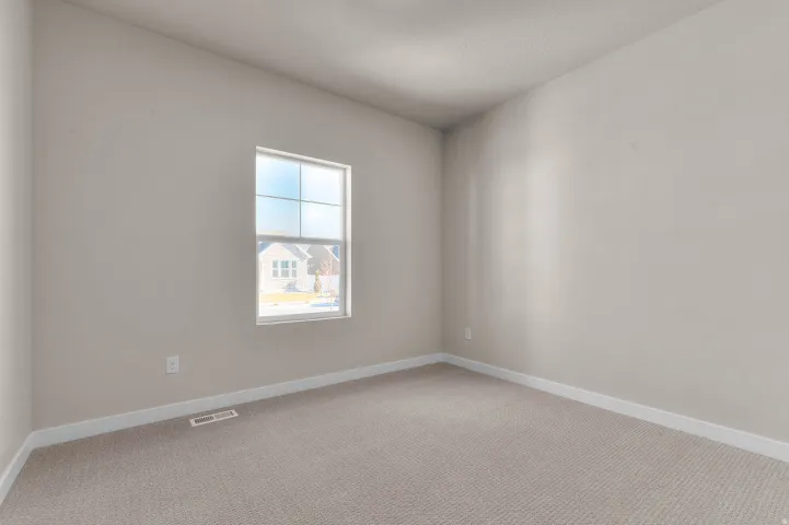 Light-filled interior space featuring neutral wall paint, white trim, and plush carpet flooring