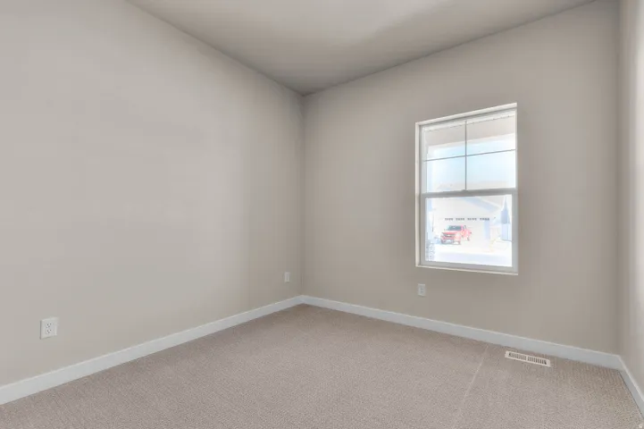 Room featuring neutral wall tones, white trim, and a textured carpet