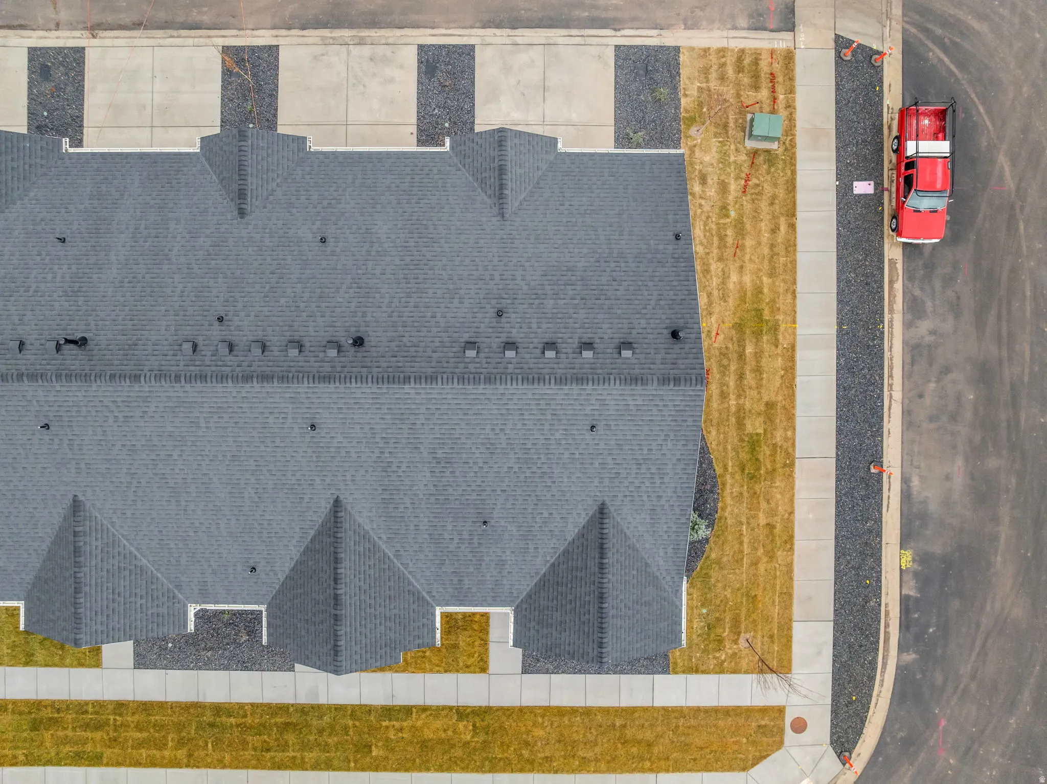 Aerial perspective showcasing a multi-unit property with a dark gray shingled roof and multiple gables