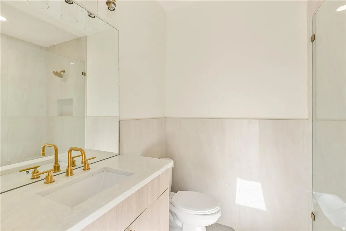 Contemporary bathroom vanity featuring an integrated sink, gold-finish faucet, and coordinating cabinet hardware