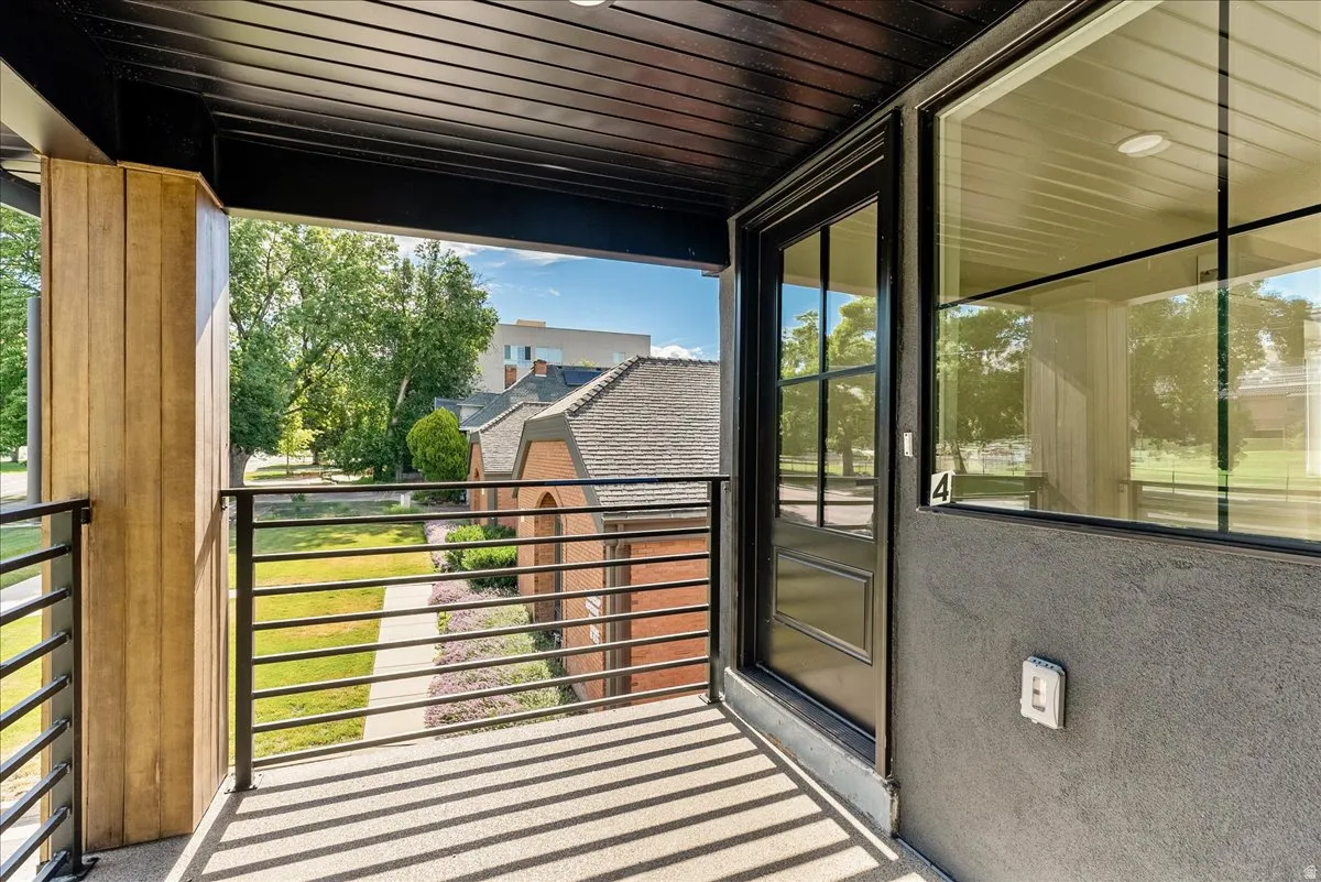 Private balcony featuring dark metal railings and a wood-finish accent column