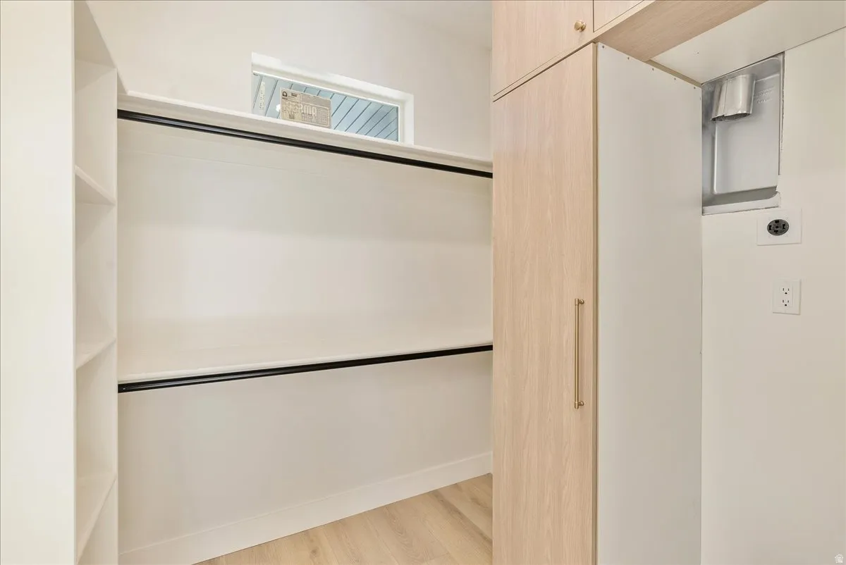 Custom closet system featuring light wood-finish cabinetry, integrated shelving, and hanging rods