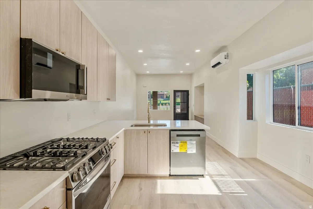 Modern kitchen with light wood-finish cabinetry and light-toned countertops