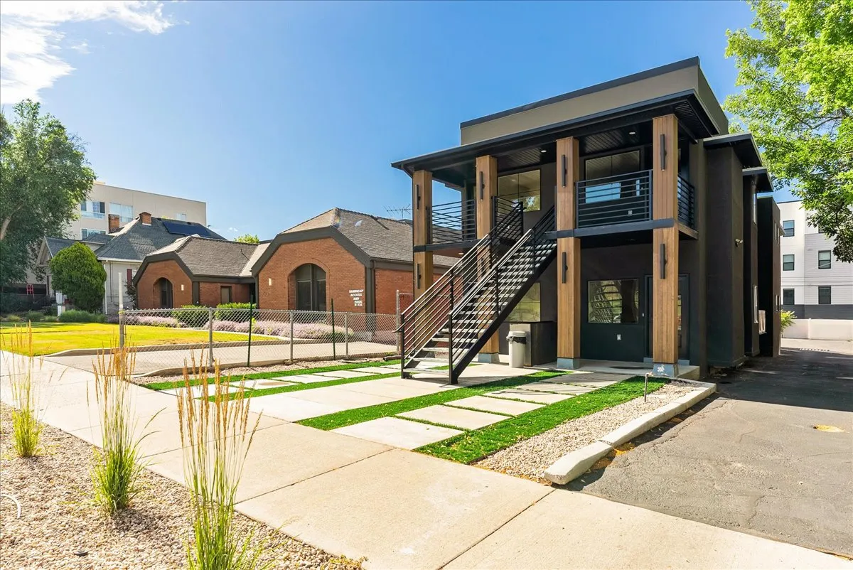 Modern multi-story facade featuring dark-toned siding and natural wood-look accents